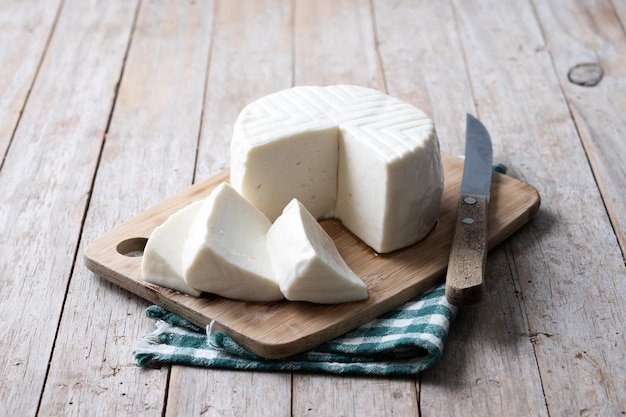 Gratis foto gesneden verse witte kaas van koemelk op houten tafel