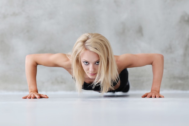 Gespierde atleet vrouw doet pushups