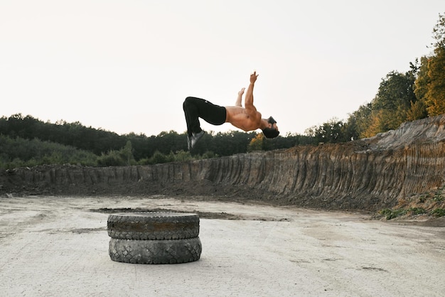 Gratis foto gespierde man met blote torso die hoog springt tijdens training