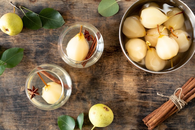 GESTOKEN PEREN pot zoete peren gestoofd in siroop of witte wijn op een groene houten tafel Het kookproces Top uitzicht