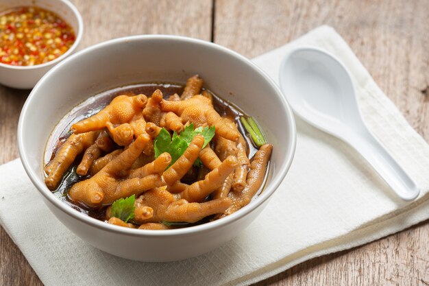 Gestoofde kippenpootsoep geserveerd met pikante vissaus