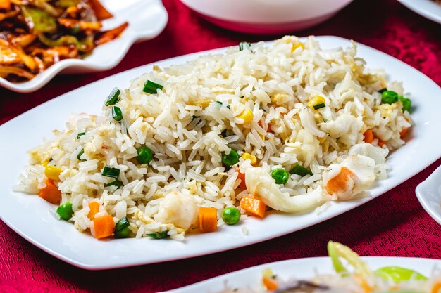 Gestoomde rijst met zeevruchten calamary corns wortel erwten zijaanzicht