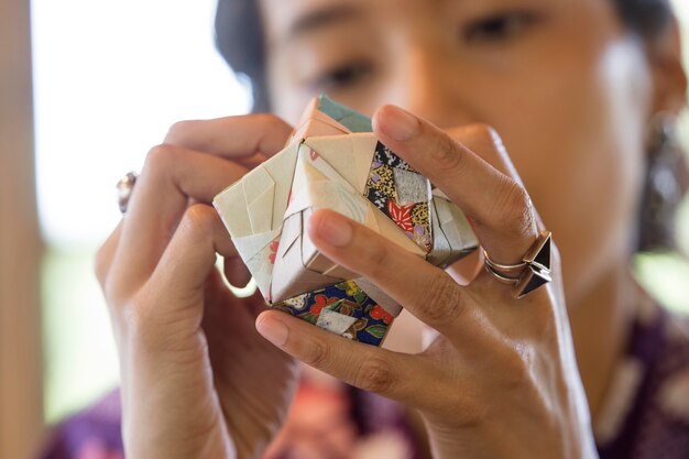 Getalenteerde vrouw die origami maakt met Japans papier