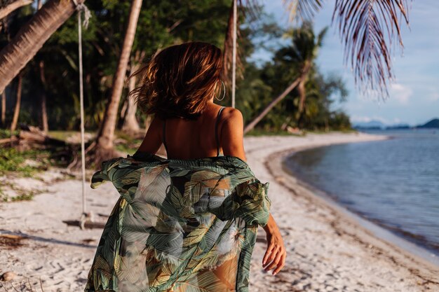 getatoeëerde blanke vrouw in denim shorts en groene trendy crop top