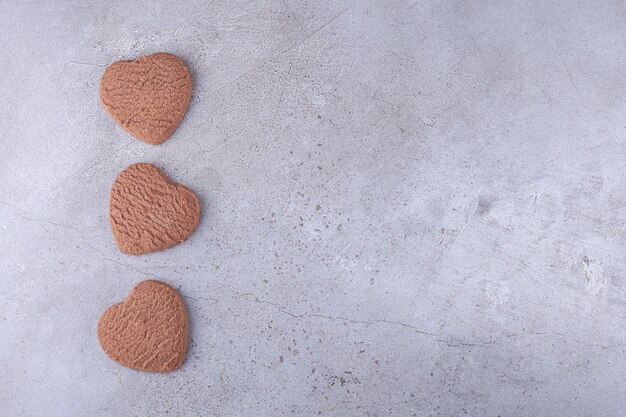 Geurige verse hartvormige koekjes die op steen worden geplaatst.
