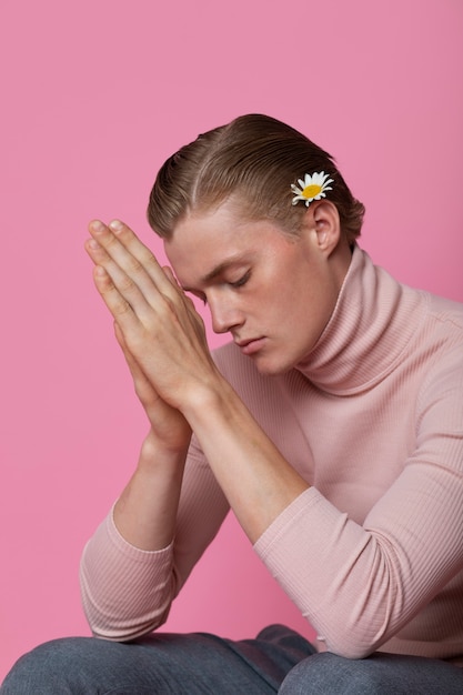 Gratis foto gevoelige man poseren met bloem zijaanzicht