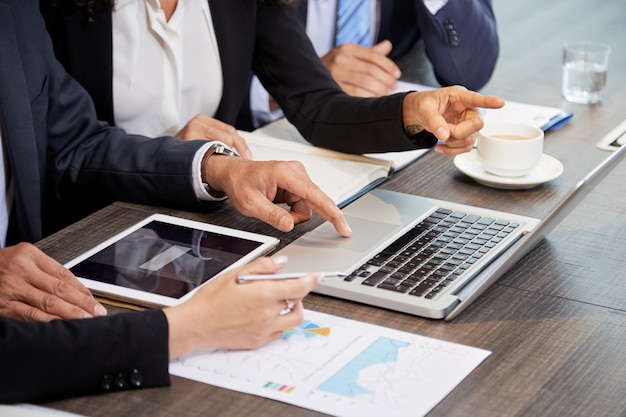 Gewas collega's met behulp van laptop aan tafel