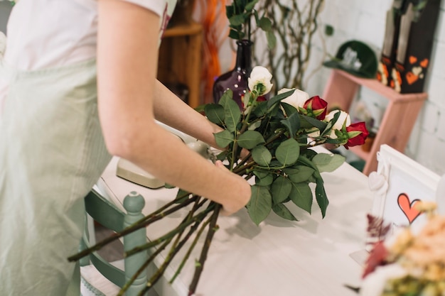 Gewasarbeider die rozen samenstellen