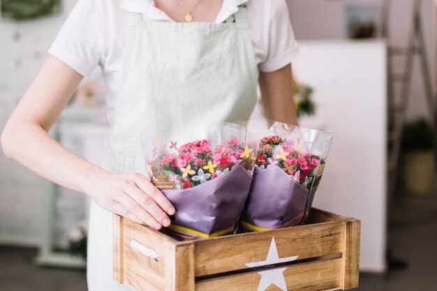 Gewasbloemist die bloemen zet in doos