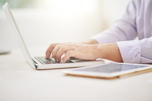 Gewassen mannelijke handen met behulp van laptop