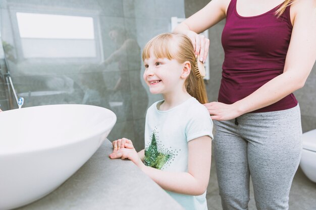 Gewasvrouw die haar van dochter kamt