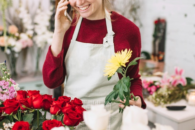 Gewasvrouw met bloem die op smartphone spreken