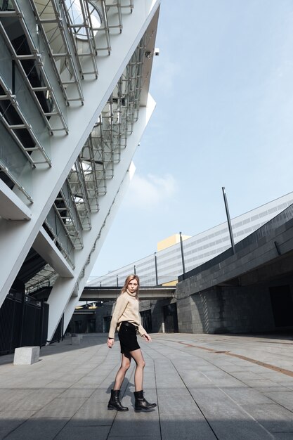 Geweldige jonge blonde dame buiten lopen. Opzij kijken.