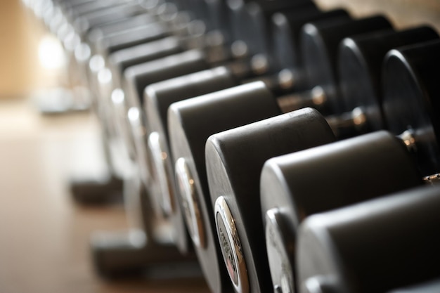 Gewicht trainingsapparatuur in een moderne sportschool binnenshuis. Close-up beeld van dumbells op een standaard. Fitnessapparatuur.