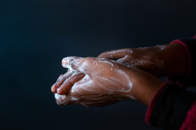 Gezeepte handen van een persoon - belang van het wassen van handen tijdens de coronaviruspandemie