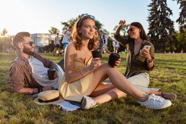 Gezelschap van vrienden die samen plezier hebben in het park en naar muziek luisteren