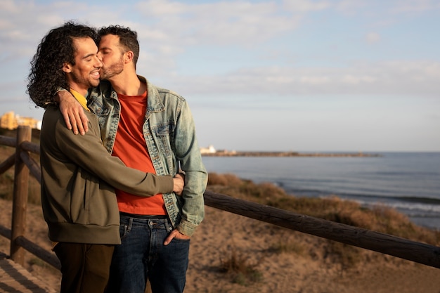 Gratis foto gezicht op een homopaar dat aanhankelijk is en samen tijd doorbrengt op het strand