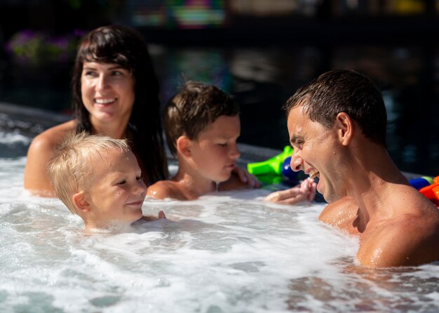 Gezin met twee kinderen genieten van hun dag aan het zwembad swimming