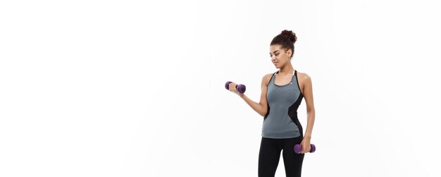 Gezond en Fitness concept Fulllength van portret Mooie Amerikaanse Afrikaanse dame in grijze fitness kleding training met halter geïsoleerd op witte achtergrond