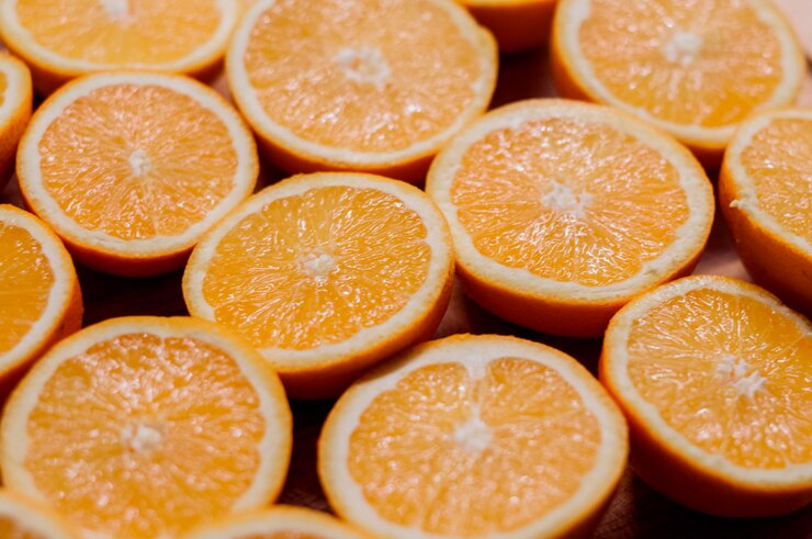 Gratis Foto gezond eten, achtergrond. sinaasappelschijfjes als achtergrondtextuur. gesneden verse sinaasappelen in vorm op houten achtergrond ingericht