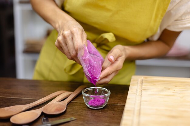 Gezond ontbijt chia pudding proces. Vrouw mix chiazaad, amandelmelk en natuurlijke kleur drakenfruit roze extract in blender.