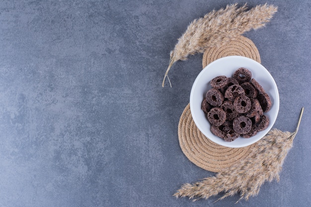 Gezond ontbijt met chocolade maïs ringen in een plaat op een stenen oppervlak