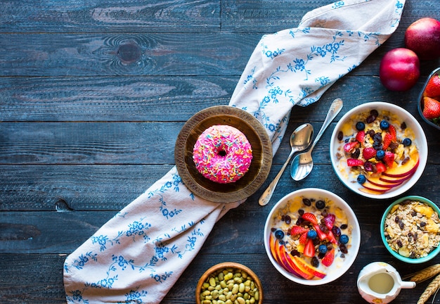 Gezond ontbijt met melk, muesli en fruit, op een houten achtergrond.