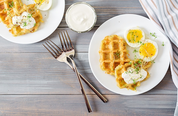 Gezond ontbijt of snack. Aardappelwafels en gekookt ei op grijze houten lijst. Bovenaanzicht Plat leggen