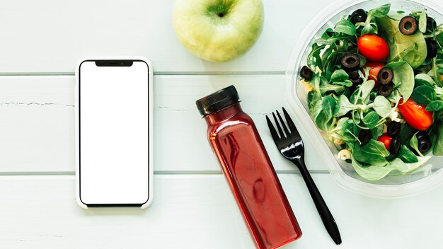 Gezond voedselconcept met smartphone naast salade