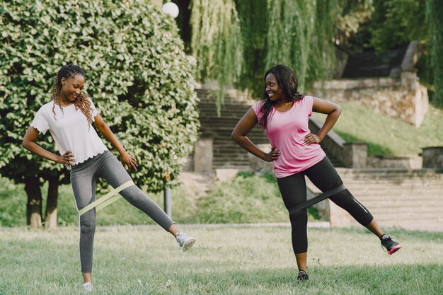 Gezonde jonge Afrikaanse vrouwen buiten in ochtendpark. Vrienden trainen.