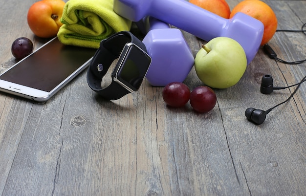 Gratis foto gezonde levensstijl dumbbell slim horloge en fruit