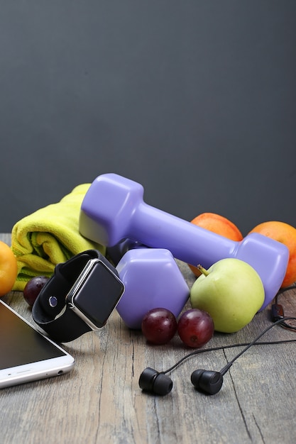 Gratis foto gezonde levensstijl dumbbell slim horloge en fruit