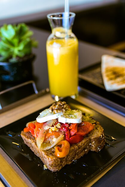 Gezonde sandwich met fruit en noten en sinaasappelsap in een restaurant.