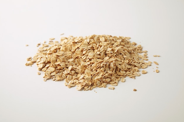 Gezonde voeding gerolde haver geïsoleerd op wit in het midden, bereid voor het koken van muesli voor het ontbijt