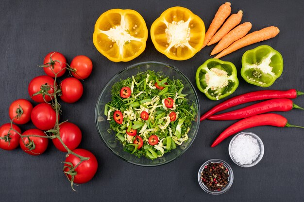 Gezonde voedsel groene salade met rode de tomaten gele paprika van de Spaanse peperpeper in een glaskom