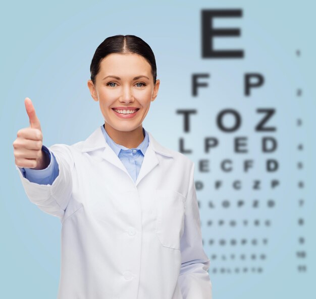Gezondheidszorg en geneeskundeconcept - glimlachende vrouwelijke arts met ooggrafiek die duimen toont