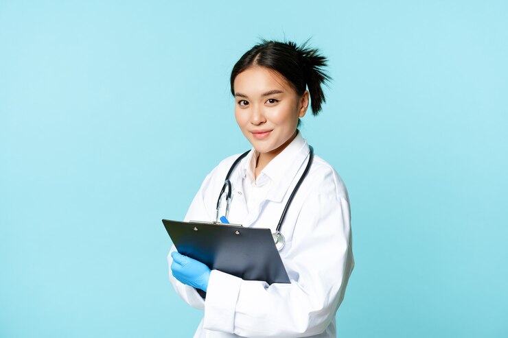Gratis Foto gezondheidszorg en kliniek concept lachende koreaanse arts vrouw arts in medisch uniform met clip...