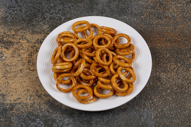 Gezouten cirkel pretzels op witte plaat.