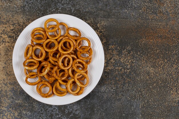 Gezouten cirkel pretzels op witte plaat.