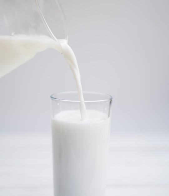 Gieten van melk insida een glas