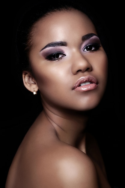 Glamour close-up portret van mooie sexy zwarte jonge vrouw model met lichte make-up met een perfecte schone huid