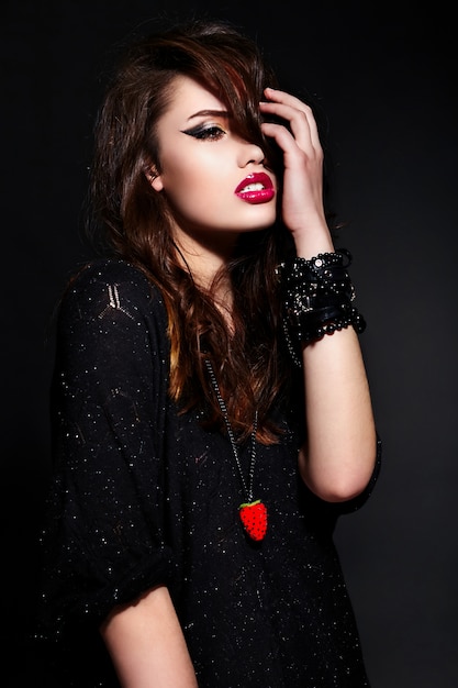 glamour portret van mooie sexy stijlvolle blanke jonge brunette vrouw model in zwarte doek met lichte make-up met accessoires met perfecte schone huid met krullend gezond haar met rode lippen