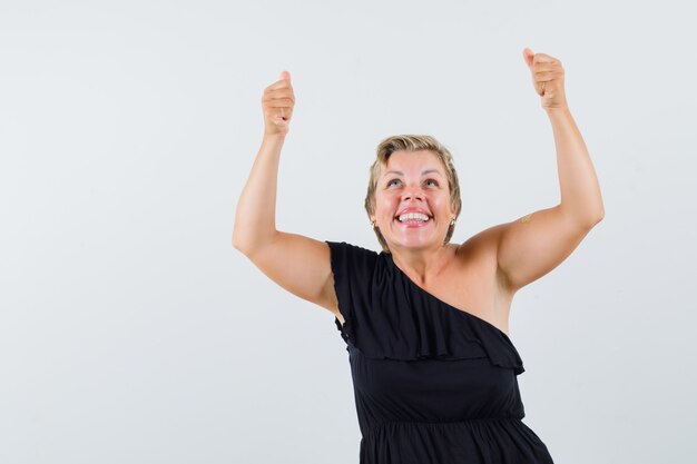 Glamoureuze vrouw die zich voordeed als het verhogen van frame in zwarte blouse vooraanzicht.