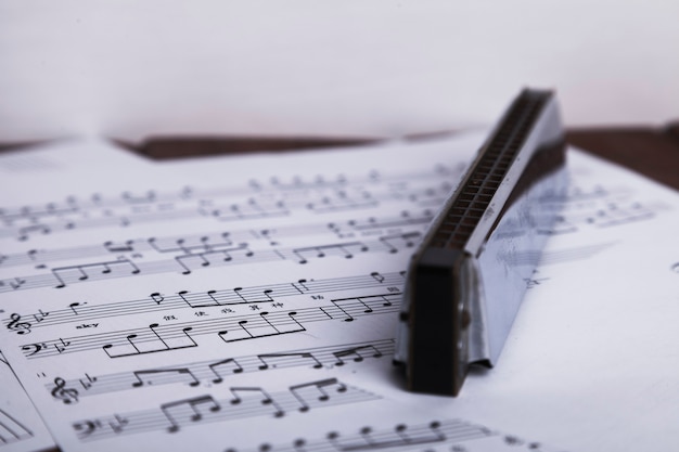 Gratis foto glanzende mondharmonica op bladmuziek