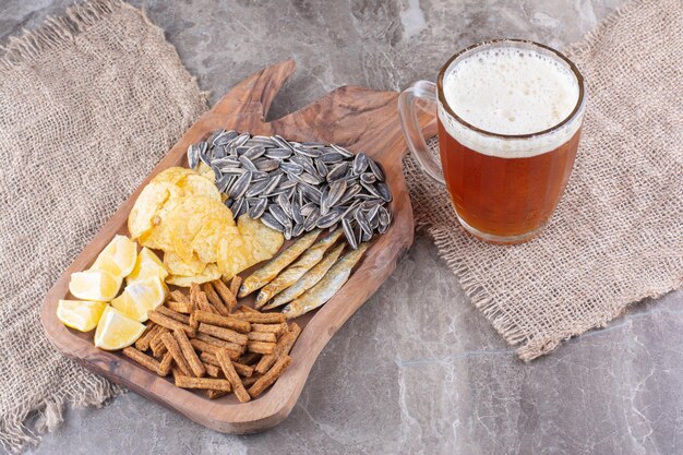 Glas bier en houten plank met snacks. Hoge kwaliteit foto