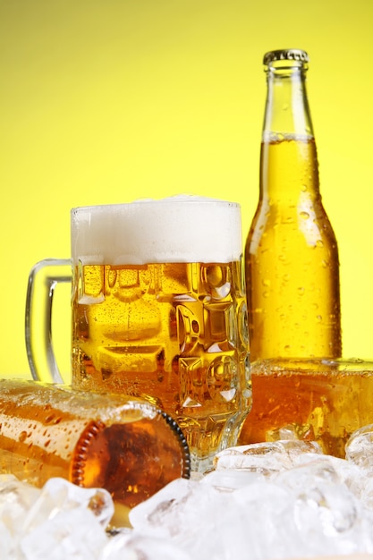 Glas bier met schuim op gele achtergrond