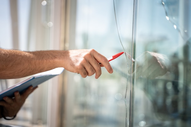 Glas gebroken uit een huis door een ongeluk, man te controleren om te repareren