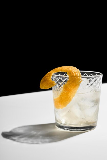 Glas gevuld met alcoholische drankcocktail en citroenschil
