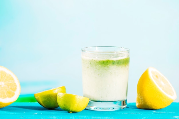 Glas gezonde groene smoothie en gesneden citrusvruchten
