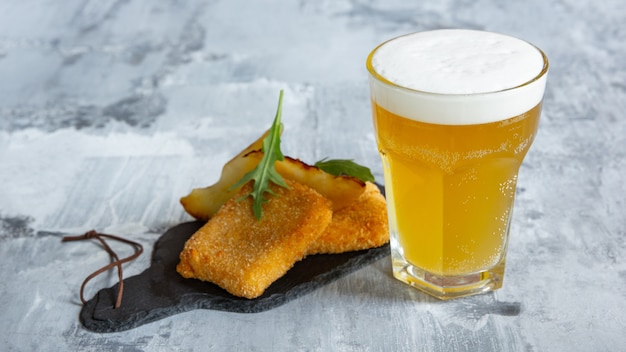 Glas licht bier op witte stenen muur.